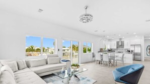 Una sala de estar moderna con un sofá, una mesa de centro de cristal y un sillón azul.