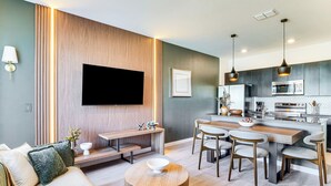 Una sala de estar moderna con un sofá, una mesa de centro y un televisor montado en la pared.