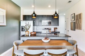A modern kitchen with dark cabinets, stainless steel appliances, and a central island. - 4 Mi to Disney! Pet-friendly Home w/ Pool Access (Kissimmee)
