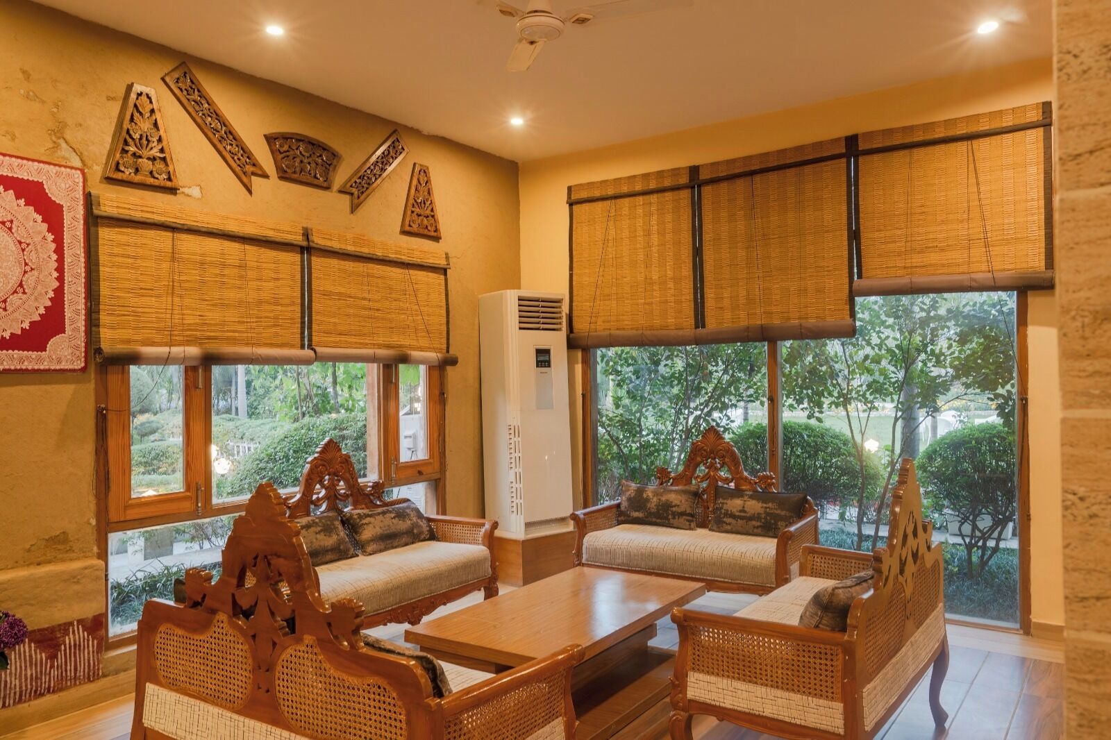 Una habitación con muebles de madera tradicionales, ventanas amplias y paneles decorativos en las paredes.