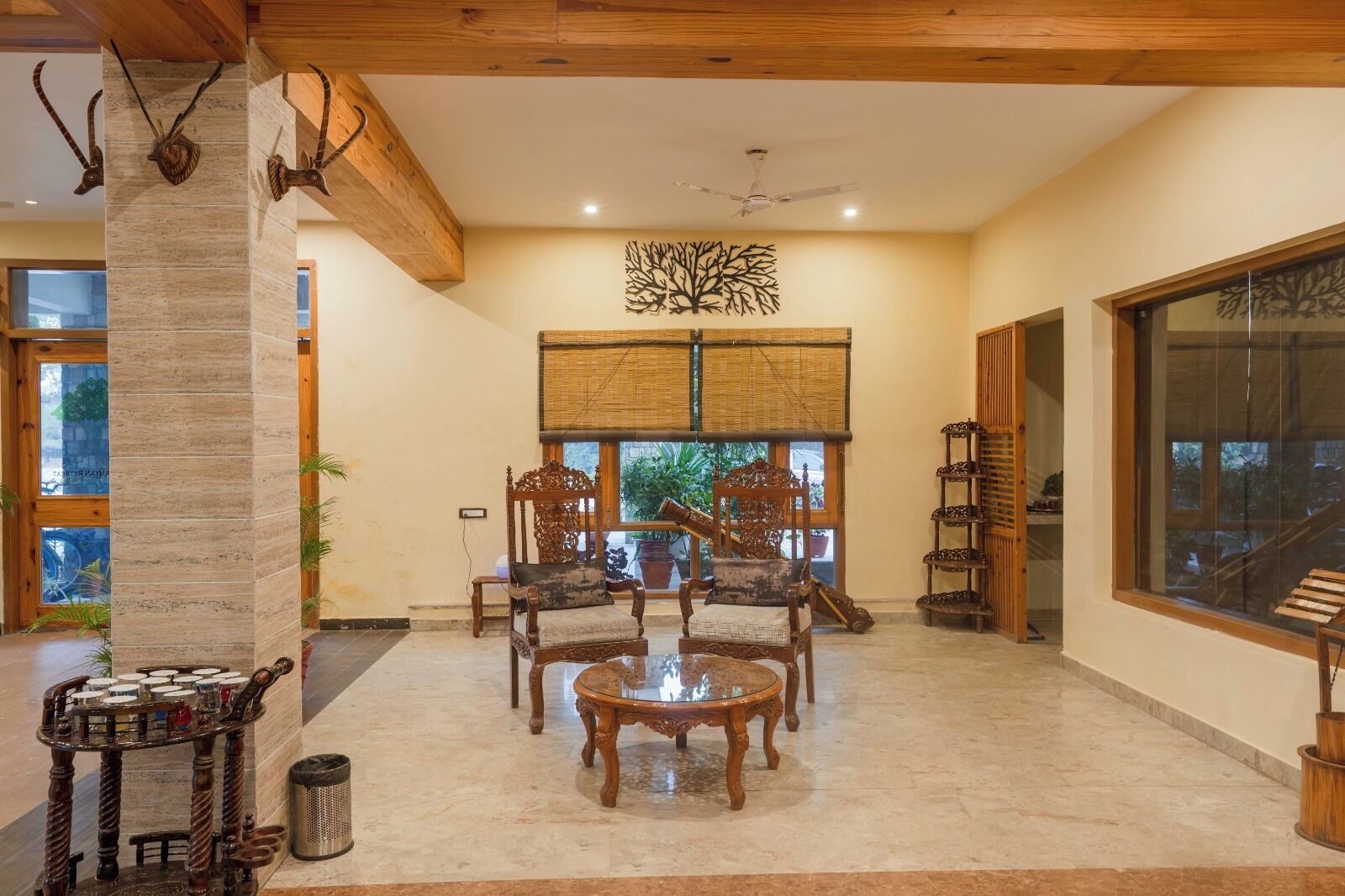 A spacious room with a large window, a wooden ceiling, and a decorative wall piece.