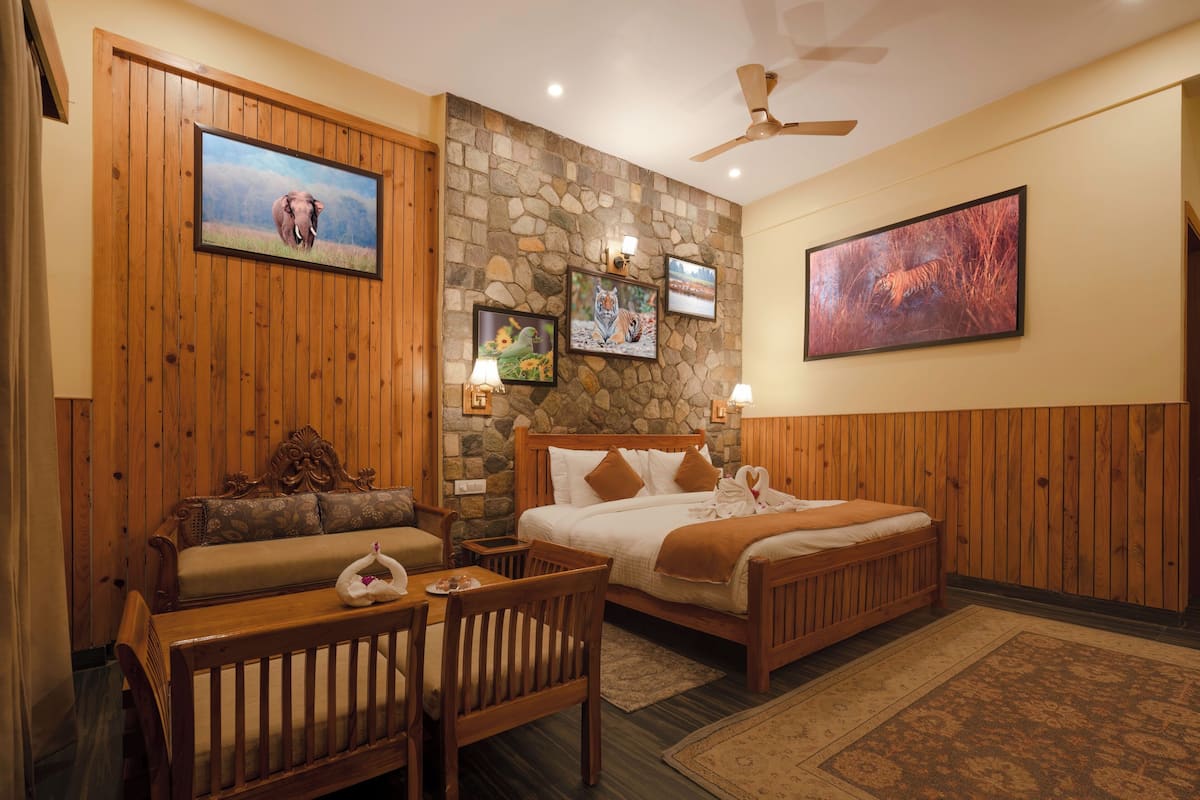 A room with a bed, a wooden bench, a table, and a stone wall.