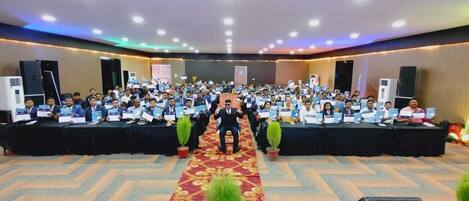 A conference room with a long table, chairs, and a podium.