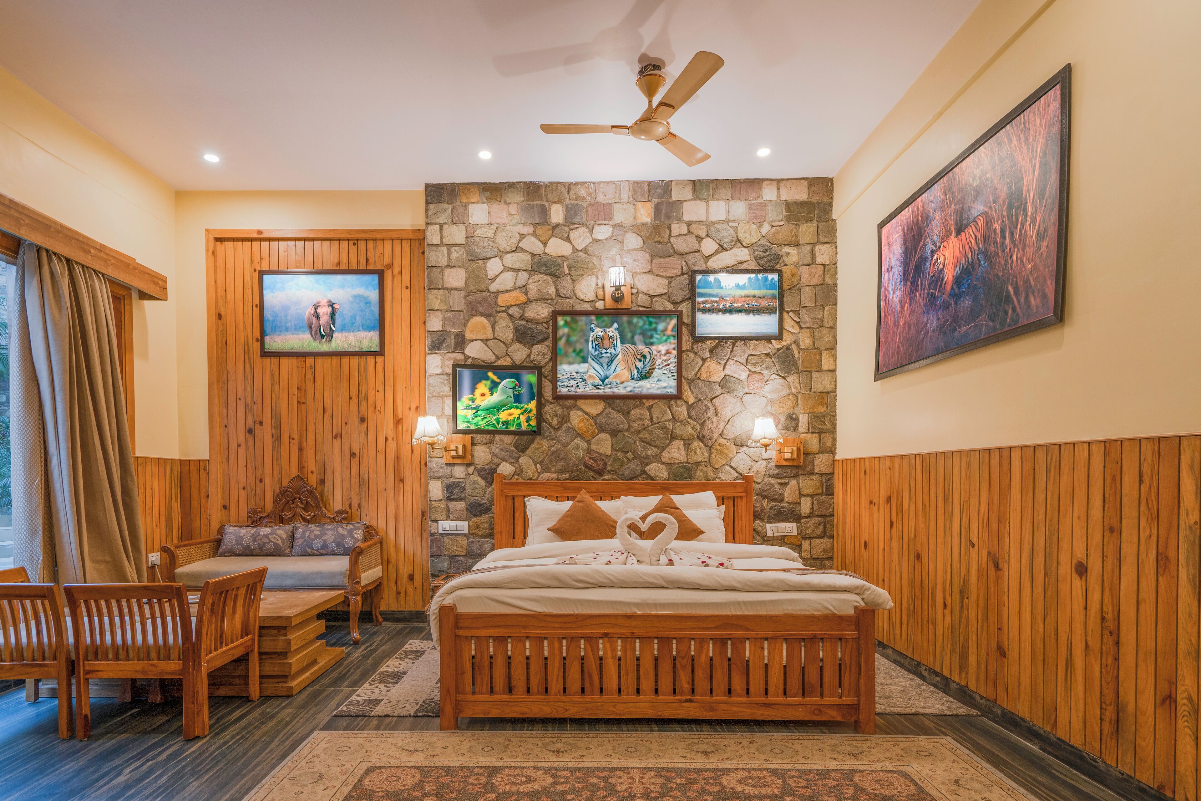 A bedroom with a stone wall, wooden bed, and a ceiling fan.