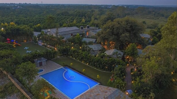 A large, private estate with a swimming pool, multiple buildings, and extensive greenery. - The Banyan Retreat by Excel Hotels & Resorts (Ramnagar)