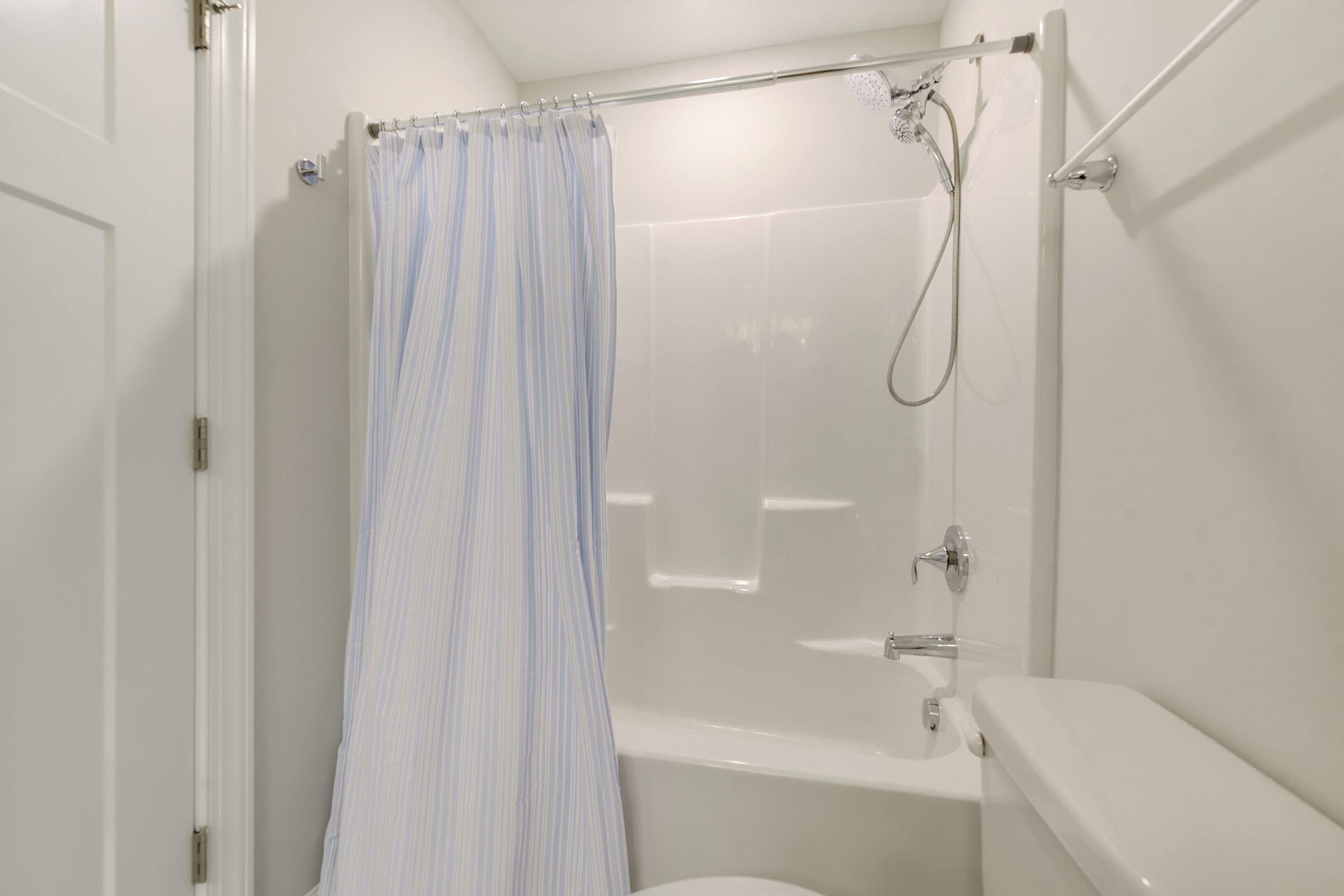 A bathroom with a shower, toilet, and bathtub.