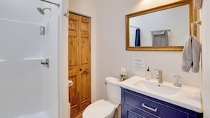 Ein Badezimmer mit Dusche, Toilette, Waschbecken und Spiegel.