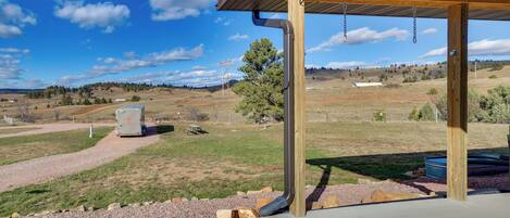 A covered outdoor area with a gravel path leading to a picnic table and a camper.