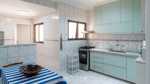 Una cocina moderna con armarios azul claro, un ventanal grande y un salpicadero de azulejos.