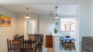 Una cocina moderna con una isla central, sillas de madera e iluminación colgante.