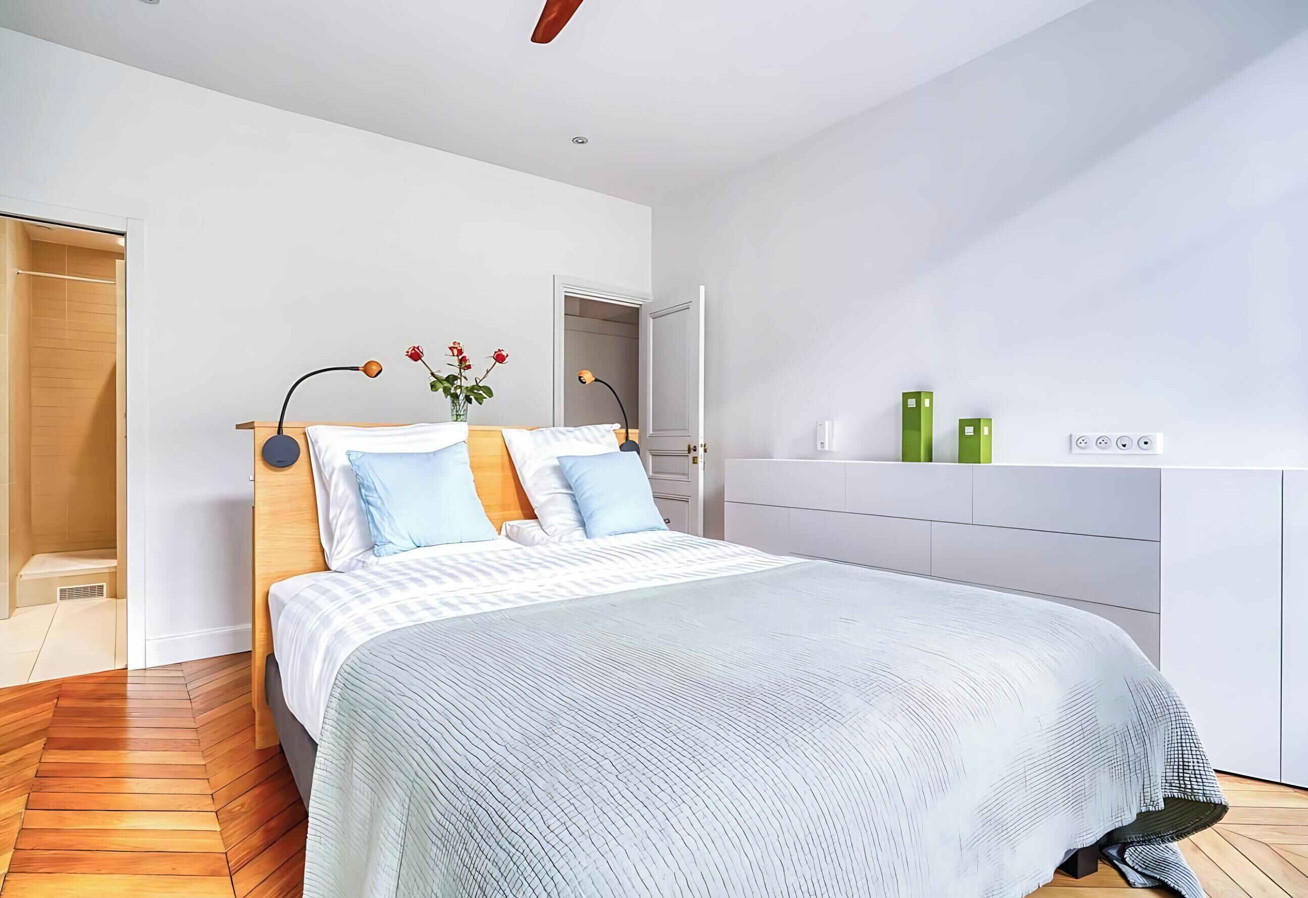 A bedroom with a bed, bedside tables, a wardrobe, and a desk with a chair.