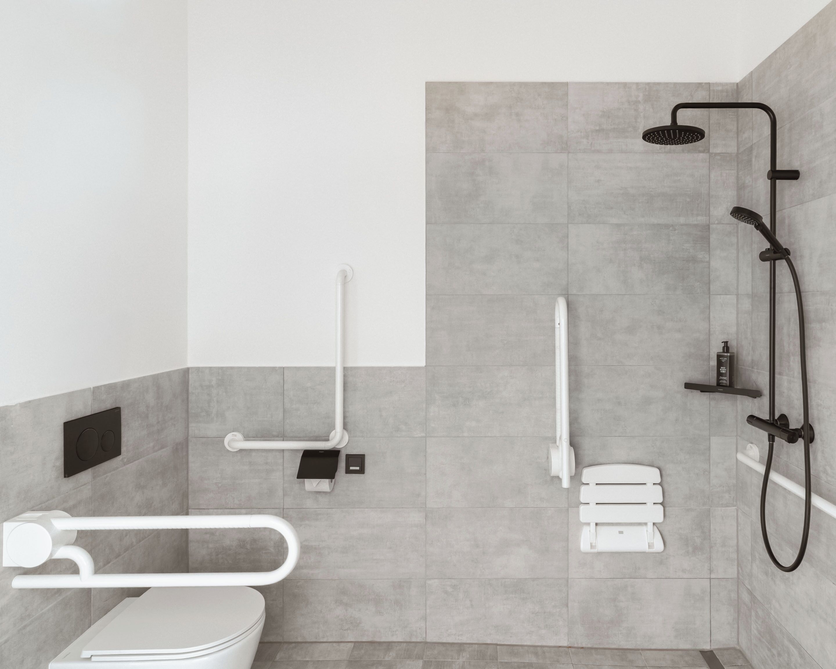A modern bathroom with a shower, toilet, and grab bars.