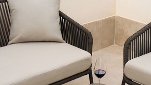A modern lounge area with a sofa and two chairs, a glass of red wine, and an open magazine on a table. - Limehome Alicante Avinguda de Jijona (Alicante)