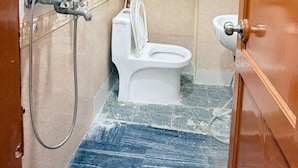 A bathroom with a toilet, bidet, and shower. - SHRI SHYAM KASHI STAY VARANASI (Varanasi)