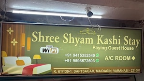 A sign for Shree Shyam Kashi Stay, a guest house with free WiFi, contact numbers, and location details. - SHRI SHYAM KASHI STAY VARANASI (Varanasi)