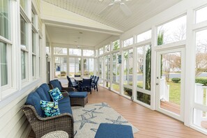 A covered patio with wicker furniture, a star-patterned rug, and a view of the street. - Beautiful 4 bedroom property in Bear Trap Dunes. (Ocean View)