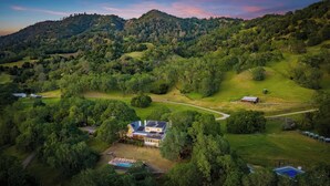 A large house with a swimming pool, surrounded by lush greenery and hills. - Alexander Valley | Hot Tub, Pool & Pickleball (Cloverdale)