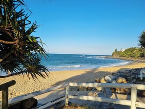 A beach with a wooden fence, rocky shoreline, and a clear blue sky. - Seaestaatmoffatquietbeachparklargefenced Yard (Sunshine Coast)