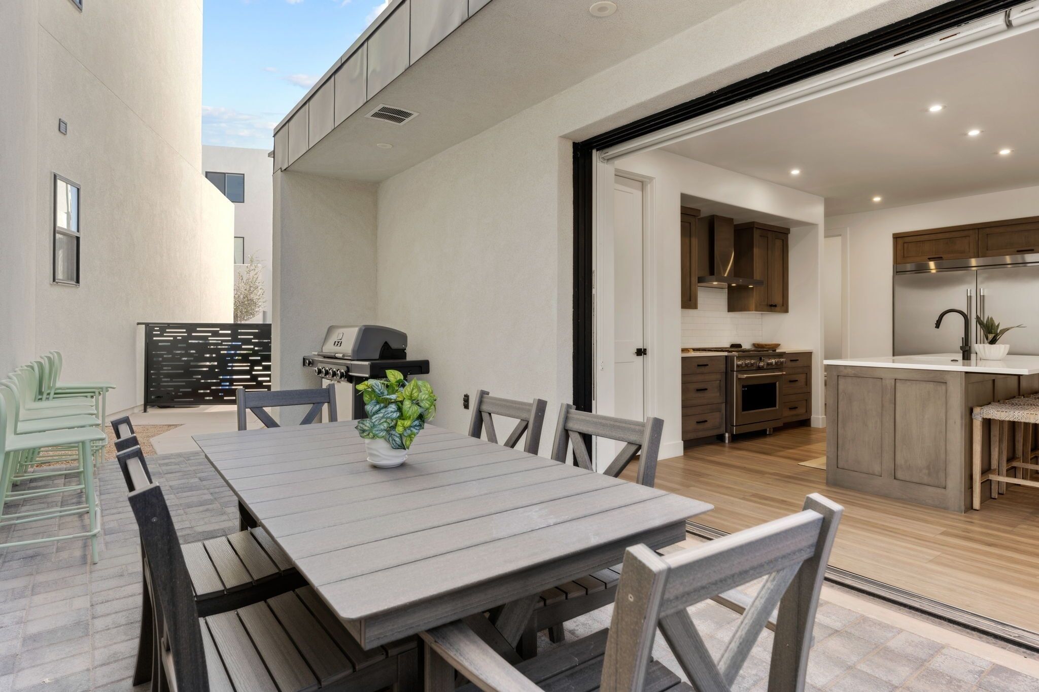 A modern kitchen with a built-in oven, a stainless steel refrigerator, and wooden cabinets.
