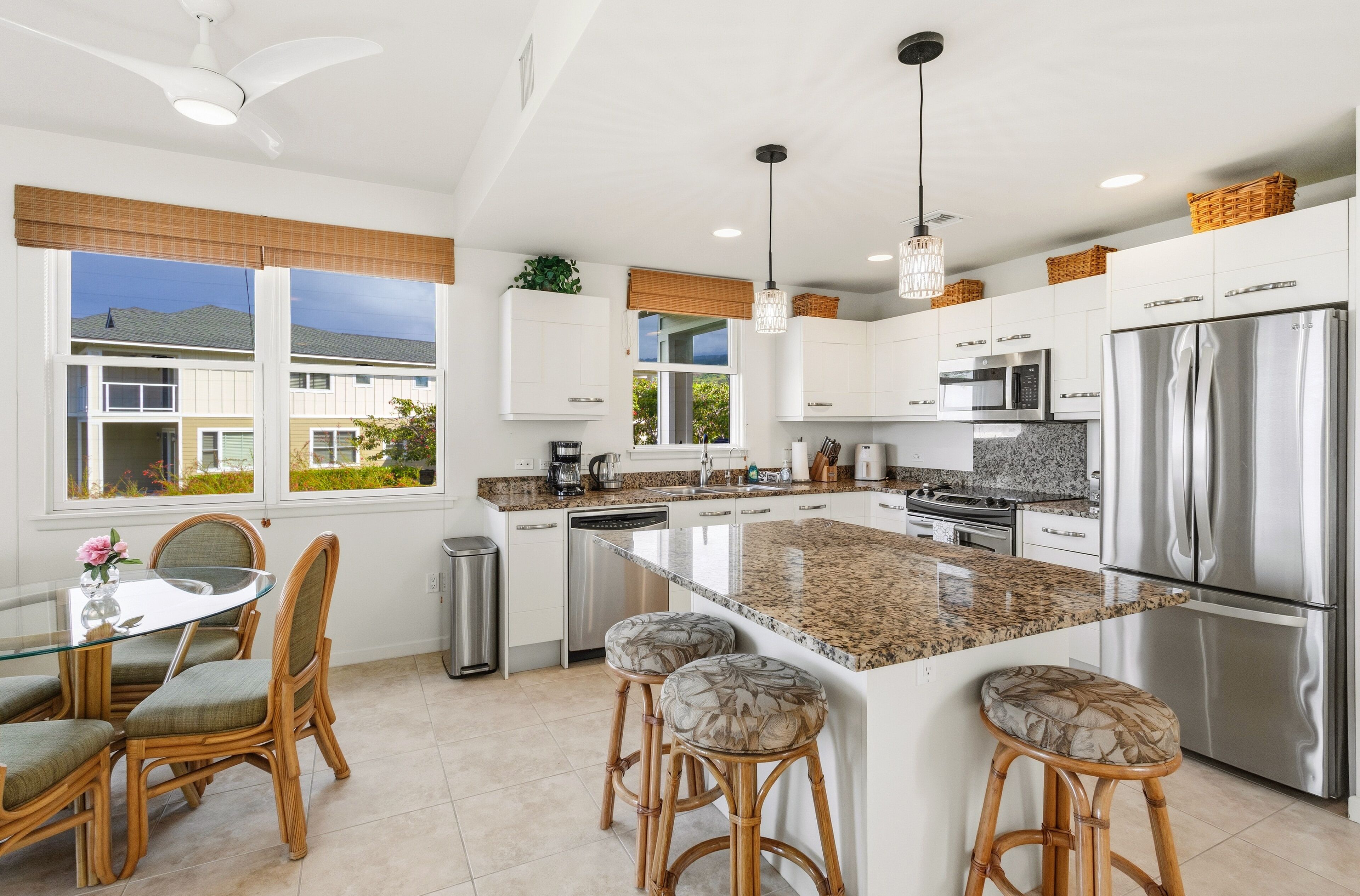 Una cocina moderna con armarios blancos, electrodomésticos de acero inoxidable y una isla grande con taburetes de bar.