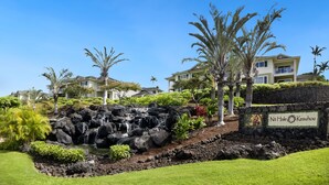 A resort with a waterfall, palm trees, and a sign reading "Na Hale Keauhou". - Big Island Na Hale O Keauhou C5 2 Bedroom Condo (Kailua-Kona)