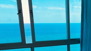 Une pièce dotée d’une grande fenêtre donnant sur la mer.