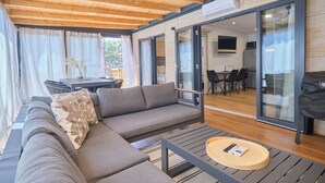 Een moderne zithoek met een hoekbank, een eettafel en een flatscreen televisie.