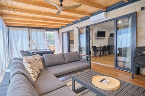 Una sala de estar moderna con un sofá modular, una mesa de centro redonda y un ventilador de techo.