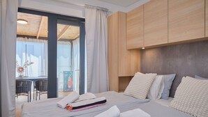 Een hotelkamer met een bed, kussens, een bureau en uitzicht.