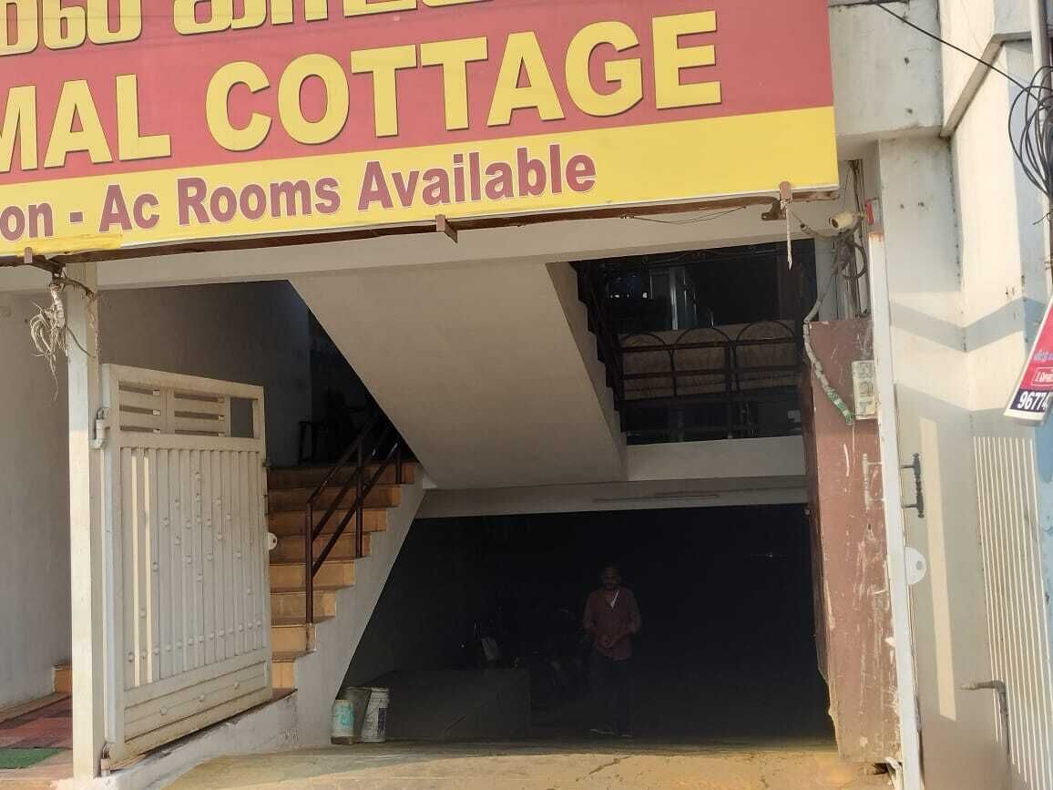 A building with a sign advertising 'Ac Rooms Available' and a staircase leading to an upper level.
