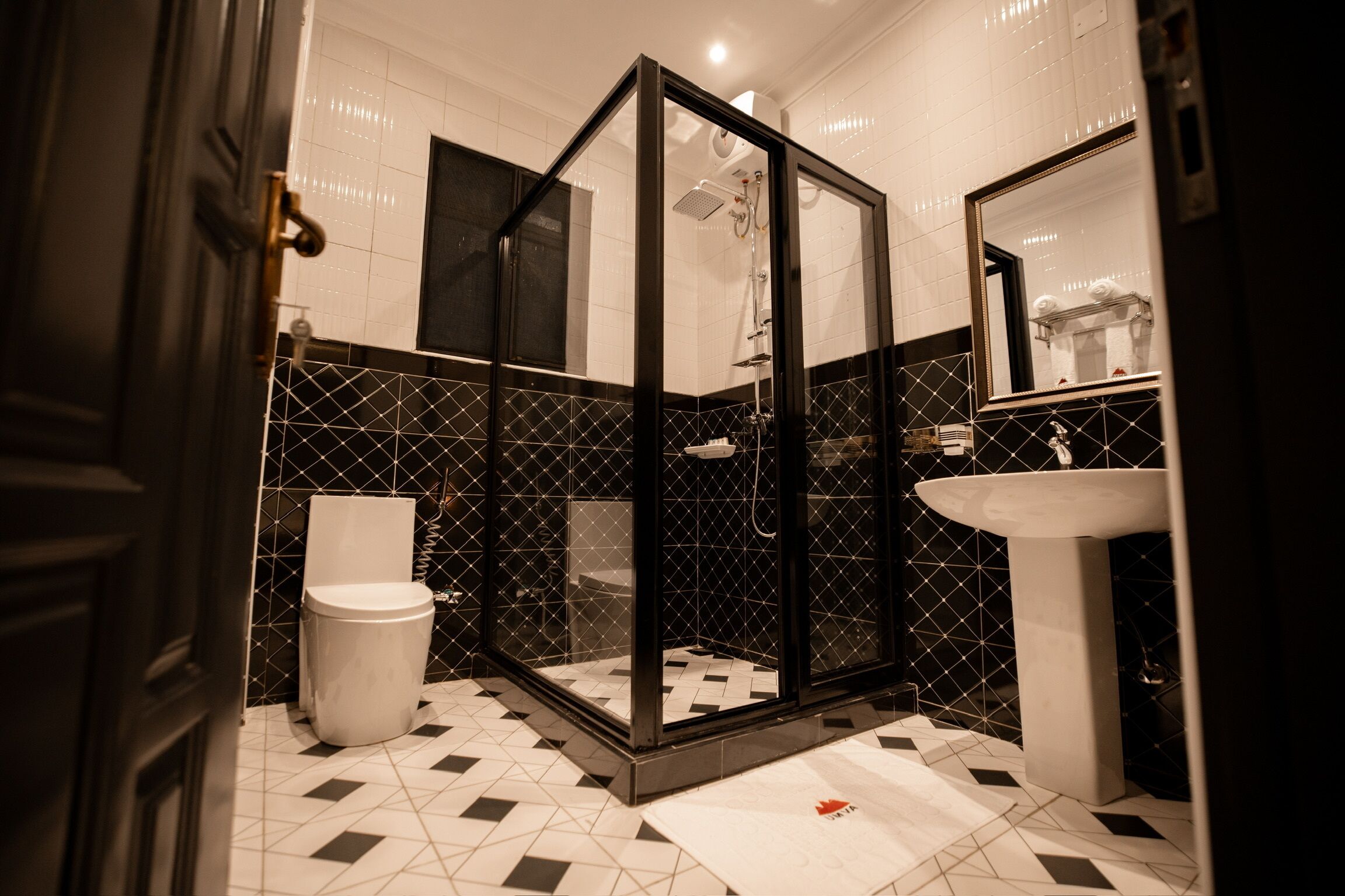 A modern bathroom with a glass-enclosed shower, a white toilet, and a sink.