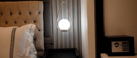 A hotel room with a tufted headboard, a bedside table with a lamp, a microwave, and a power outlet.