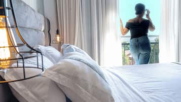 Un dormitorio con cama, lámpara de noche y vistas a un balcón.
