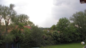 Ein Garten mit Trampolin, einer kleinen Werkstatt und einer Holz-Pergola.