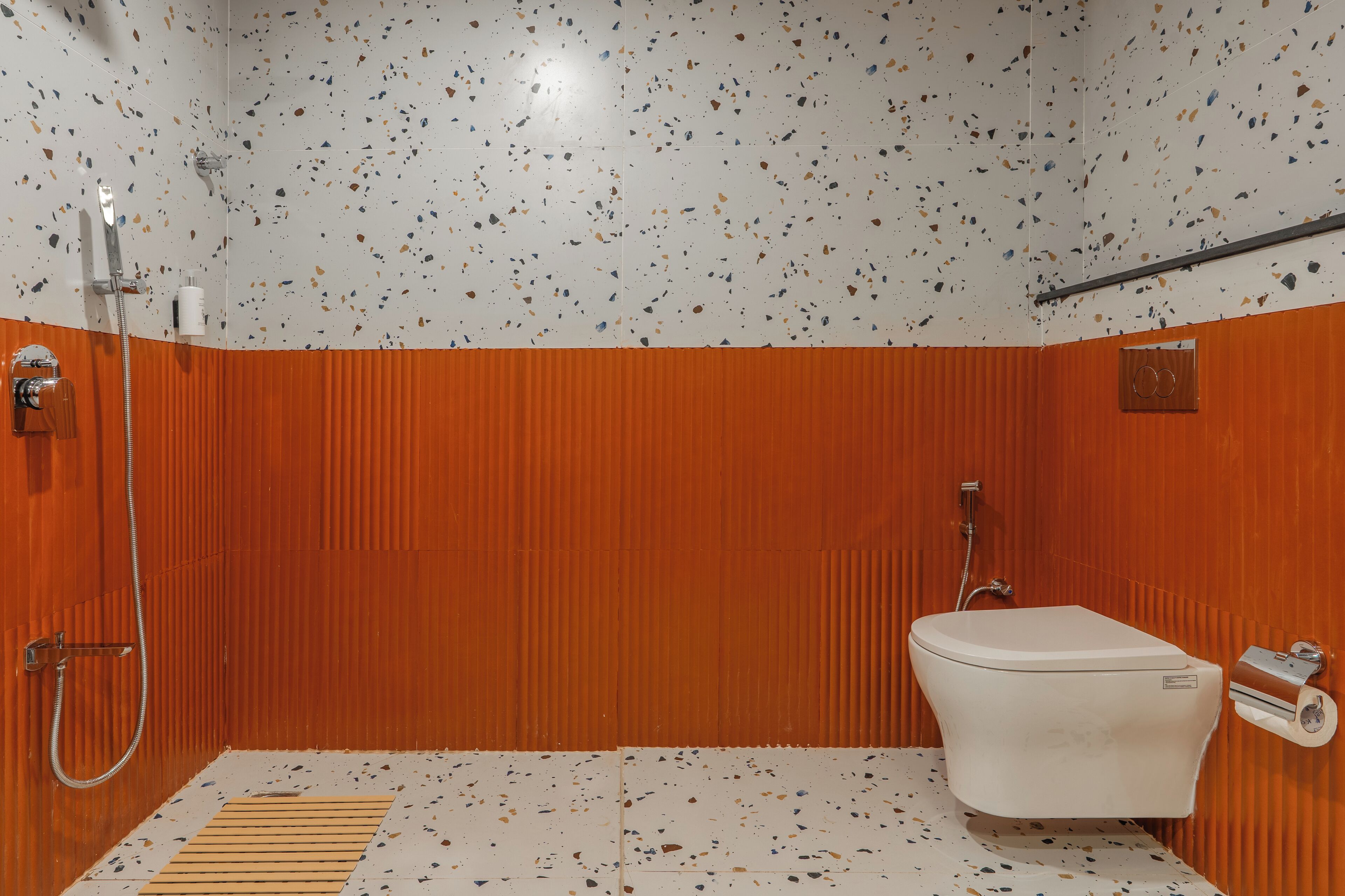 A bathroom with a shower, toilet, and a towel rack.