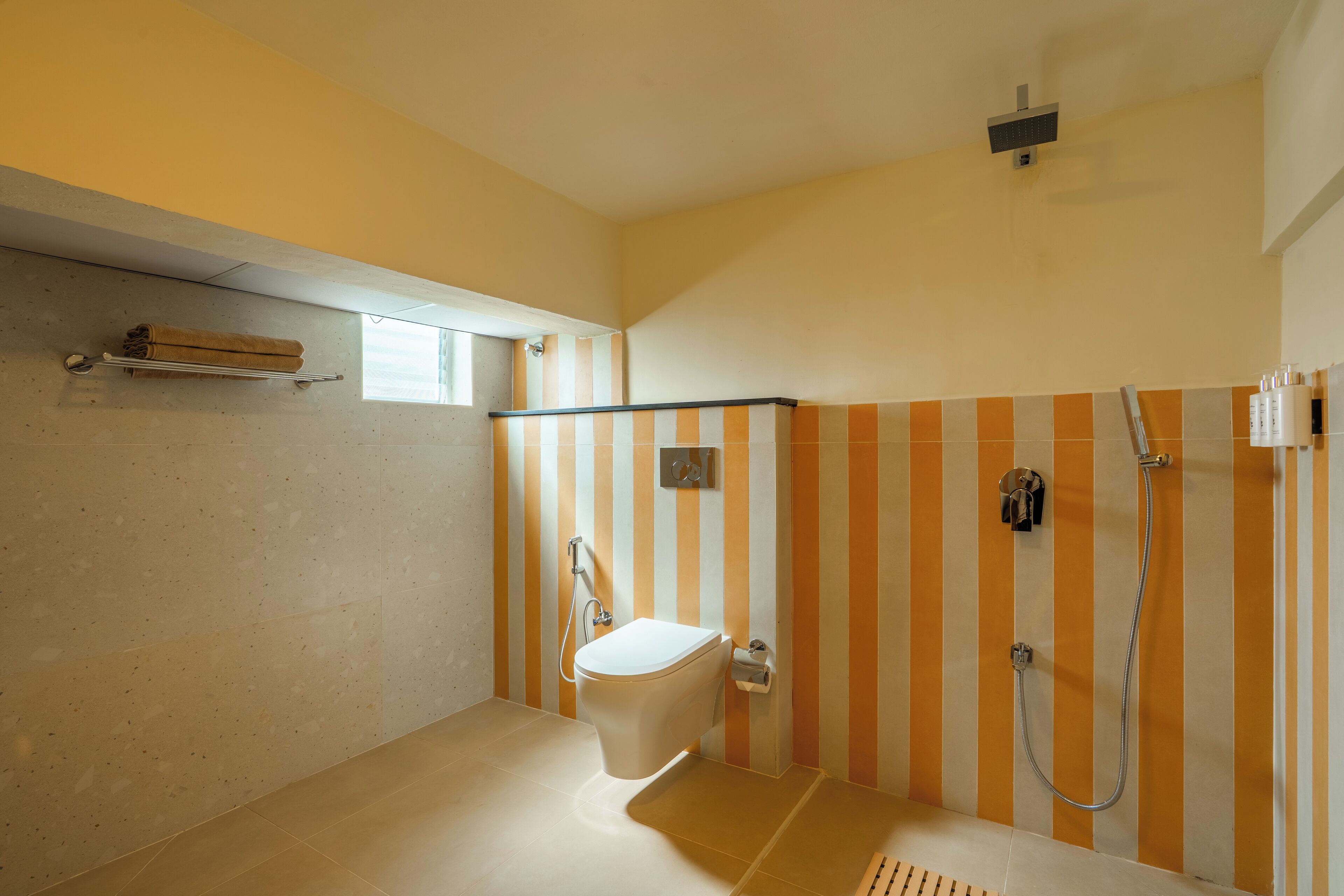 A bathroom with a toilet, shower, and a towel rack.
