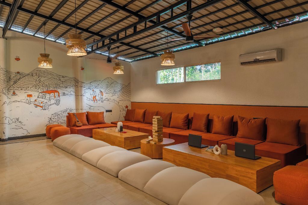 Un salon moderne doté d’un haut plafond, d’un grand canapé, d’une table basse et d’une fresque murale.