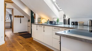 Una cocina moderna con tragaluz, suelo de madera y armarios blancos.