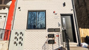 Ein mehrstöckiges Gebäude mit Ziegelverkleidung, großen Fenstern und einem sichtbaren Sprinkleranlage.