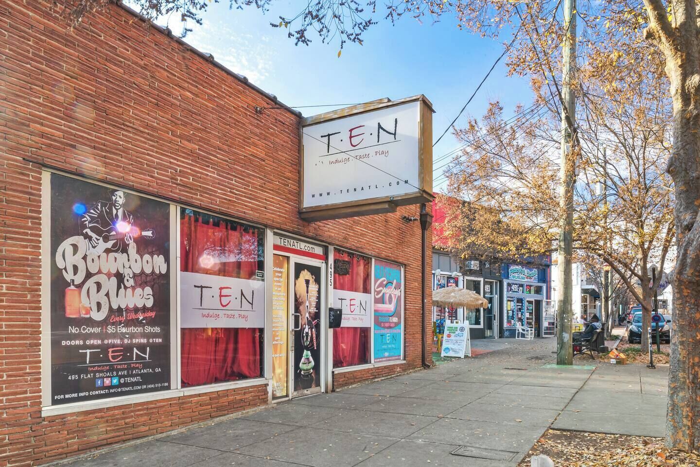 A brick building with large windows advertising Bourbon Blues and Ten events.
