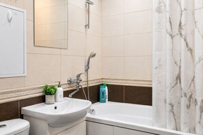 A bathroom with a sink, toilet, bathtub, and shower. - Apartment near Komarovsky Market (Minsk)