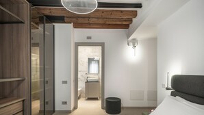 A modern bedroom with a bed, a bedside table, a nightstand, a wall-mounted lamp, and a wooden ceiling. - Palace Of The Elect Green Apartment R&R (Venecia)