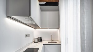 A compact kitchen with a built-in stove, a coffee maker, and a sink. - Palace Of The Elect Green Apartment R&R (Venecia)