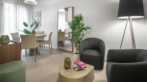 A modern living room with a dining area, a large mirror, and a floor lamp. - Palace Of The Elect Green Apartment R&R (Venecia)