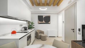 Una cocina moderna con armarios blancos, techo de madera y diseño minimalista.