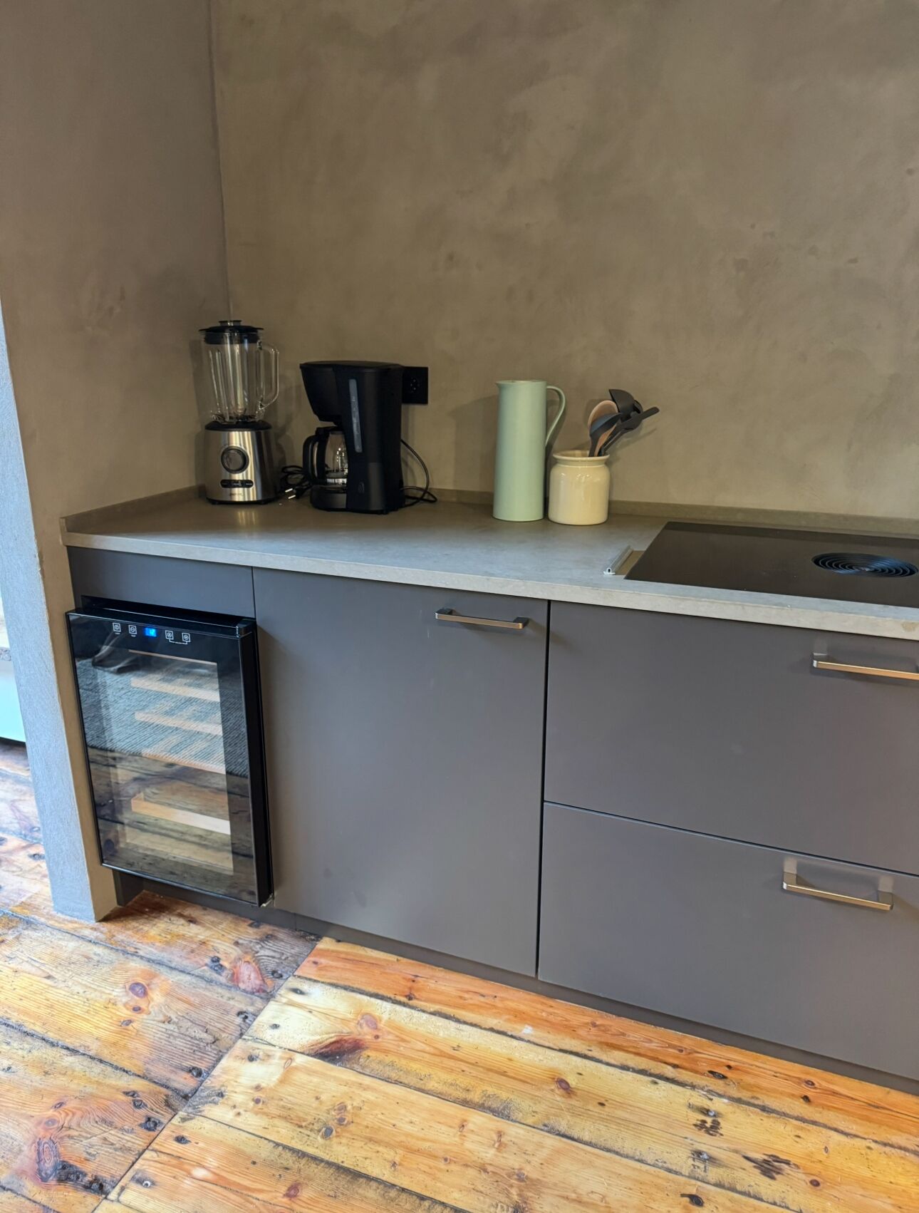 Eine Küche mit Geschirrspüler, Kaffeemaschine und Mixer auf der Arbeitsplatte.