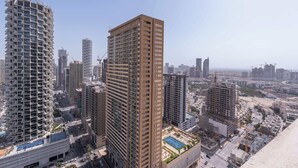 A high-rise building with a modern design, featuring multiple balconies and a rooftop pool area. - StayShort - 1 Bed in JVC Sleeps 4 with City Views! (Jumeirah Village Circle)