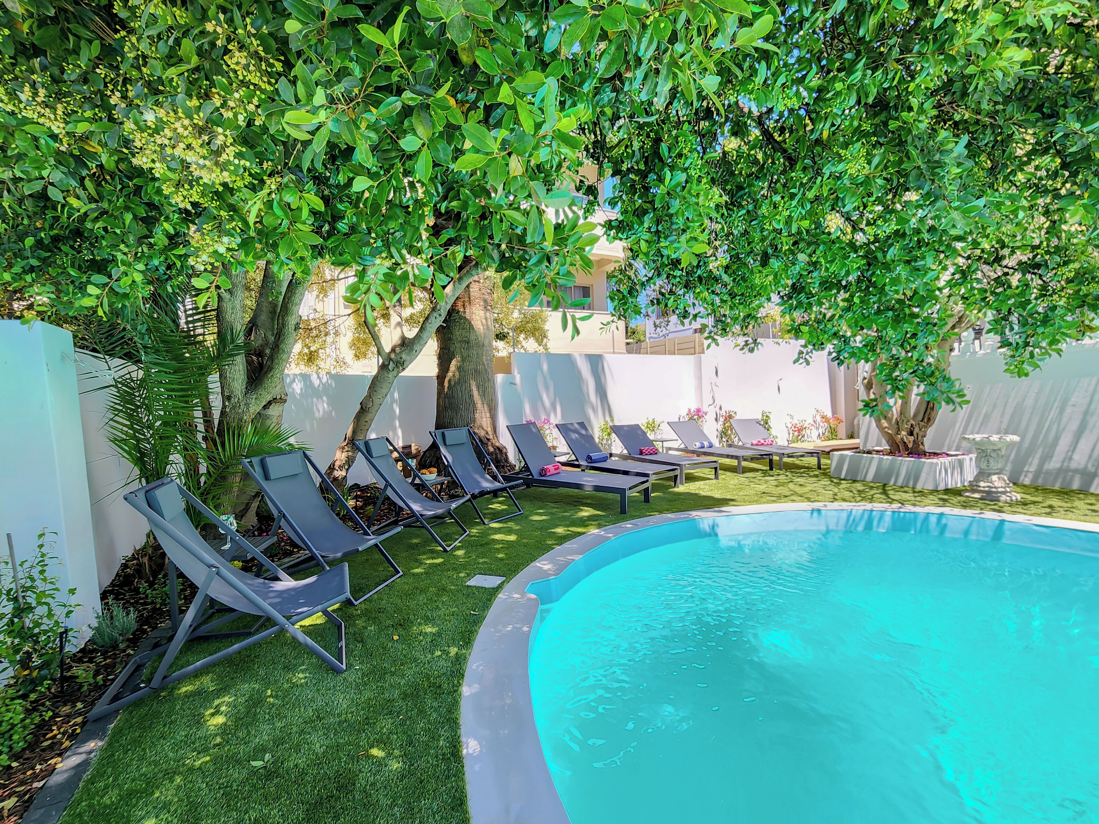 A pool area with lounge chairs and a small pool.