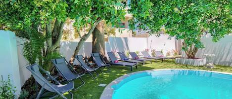 A pool area with lounge chairs and a small pool.