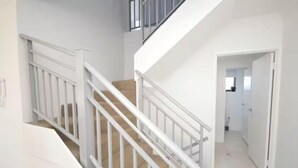 Eine Treppe mit weißen Geländern, die zu einer zweiten Etage führt.